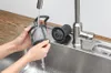 Hands washing a dishwasher filter under a faucet in a sink. Anteprima dell’immagine prodotto