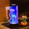 A jellyfish lamp is placed on a desk next to a small potted plant and other decorative items. Anteprima dell’immagine prodotto