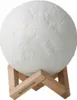 A white moon lamp on a wooden stand. Produktbild-Vorschau