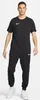 A man wearing a black Nike t-shirt and black Nike sweatpants. Produktbild-Vorschau