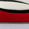 A close-up view of a rug with a red, black, and white pattern. Produktbild-Vorschau