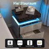 A modern nightstand with LED lighting is shown next to a bed, with icons indicating features at the bottom. Produktbild-Vorschau