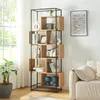 A modern living room with a bookshelf filled with decor and books, next to a sofa. Náhled obrázku produktu