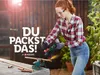 A woman is using an angle grinder to cut a copper pipe outdoors. Produktbild-Vorschau
