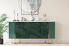 A green marble-patterned sideboard with gold legs, displayed in a room setting with decorative items on top and a plant beside it. Náhľad obrázku produktu