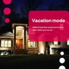 A house at night with lights on, with a pink overlay promoting 'Vacation mode'. Produktbild-Vorschau