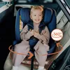 A young child is sitting in a car seat in a car. Produktbild-Vorschau