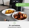 An air fryer with two bowls of food, one with fries and the other with chicken wings, on a kitchen counter. Voir les images du produit