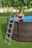 A woman is standing in an above-ground pool next to a ladder. Produktbild-Vorschau