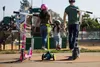 A family is at a park with scooters. Produktbild-Vorschau