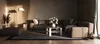 A modern living room with a sectional sofa, coffee table, and ottoman. Náhled obrázku produktu