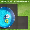 An overhead view of a round swimming pool on a grassy area, with black interlocking mats surrounding it. A person is floating in the pool on a pink inflatable ring, with a beach ball and a pineapple-shaped inflatable nearby. Náhľad obrázku produktu