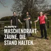 Three men standing outdoors with fencing materials. Produktbild-Vorschau