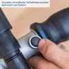 A close-up of a hand pressing a button on a tool, likely for changing an accessory. Produktbild-Vorschau