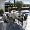 An outdoor dining set with chairs and a table next to a swimming pool. Produktbild-Vorschau