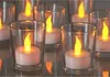 Several glass votive holders with LED tea lights inside, arranged closely together. Náhled obrázku produktu