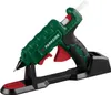 A green and black hot glue gun with a red trigger, resting on its black charging stand. Produktbild-Vorschau