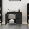 A black bathroom vanity with a white sink and faucet, shown with its doors open to reveal towels inside. Produktbild-Vorschau