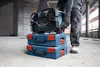A person is placing a radio on top of two toolboxes at a construction site. Produktbild-Vorschau