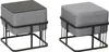 Two identical square ottomans with gray upholstered seats and black metal frames are shown against a white background. One ottoman has a black tabletop. Produktbild-Vorschau