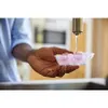 A person's hand holding a pacifier tray under a faucet. Anteprima dell’immagine prodotto