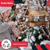 A young girl is filling a bird feeder with birdseed in a snowy outdoor setting. Produktbild-Vorschau