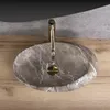 A close-up overhead view of a marble sink with a gold faucet. Anteprima dell’immagine prodotto