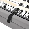 A close-up view of the underside of a bed frame, showing the metal structure, wooden slats, and a grey fabric skirt. Náhled obrázku produktu
