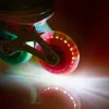 A close-up shot of the wheels of a pair of inline skates, with colorful LED lights illuminating them. Náhľad obrázku produktu