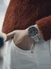 A person wearing a watch and a fuzzy sweater, with their hand in their pocket. Náhled obrázku produktu
