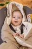 A baby wrapped in a blanket in a car seat. Produktbild-Vorschau