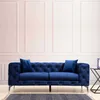 A blue tufted sofa is shown in a room with paneled walls. Voir les images du produit