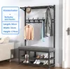 A dark gray metal coat rack with a built-in bench and shoe shelves, displaying various clothing items and shoes. Produktbild-Vorschau