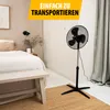 A bedroom scene with a stand fan. Voir les images du produit