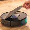 A hand is shown lifting the lid of a black robot vacuum cleaner on a wooden floor. Náhled obrázku produktu