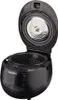 An open black CUCKOO rice cooker with its inner pot removed, showing the heating element and control panel. Voir les images du produit