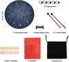 A flat lay of a steel tongue drum and its accessories, laid out on a white background. Produktbild-Vorschau