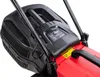 Close-up view of the top and handle area of a red and black electric lawnmower. Produktbild-Vorschau