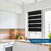 A modern kitchen with white cabinets and a wooden backsplash, featuring a window with black and white striped roller blinds. Produktbild-Vorschau