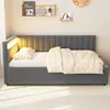 A dark gray upholstered daybed with a headboard, dressed with a white polka dot fitted sheet, a beige striped duvet, and a beige striped pillow. The daybed has integrated LED lighting along the headboard. Shelves with decorative items are mounted on the wa Voir les images du produit