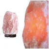 Two Himalayan salt lamps are shown against a white background. One lamp is on the left, smaller and unlit, on a wooden base. The other lamp is on the right, larger and lit from within, glowing orange-red. Produktbild-Vorschau