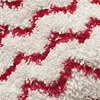 A close-up view of a textured fabric with a red zigzag pattern on a white background. Produktbild-Vorschau