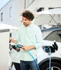 A man is charging an electric car outdoors. Náhľad obrázku produktu
