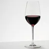 A single glass of red wine on a white surface against a white background. Produktbild-Vorschau