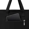 A close-up shot of a black bag with a smartphone in a zippered pocket. Produktbild-Vorschau