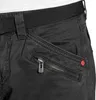 Close-up of the pocket area of black cargo pants, showing a zipper and a red button. Produktbild-Vorschau