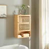 A wooden bathroom cabinet mounted on a gray wall next to a window with sheer curtains. Podgląd zdjęcia produktu