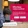 A young person is studying at a table while a smart lamp is being controlled by voice command. Produktbild-Vorschau
