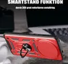 A red phone case with a ring holder is shown in a close-up shot, with a blurred background suggesting a desk or workspace. Produktbild-Vorschau