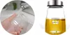 A collage showing two scenes: one of a hand washing a glass cup with a label, and another of a glass bottle filled with oil and a label. Podgląd zdjęcia produktu